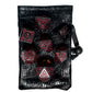 Large Tarrasque plastic dnd dice on top of leather dungeons and dragons dice bag with monster eye