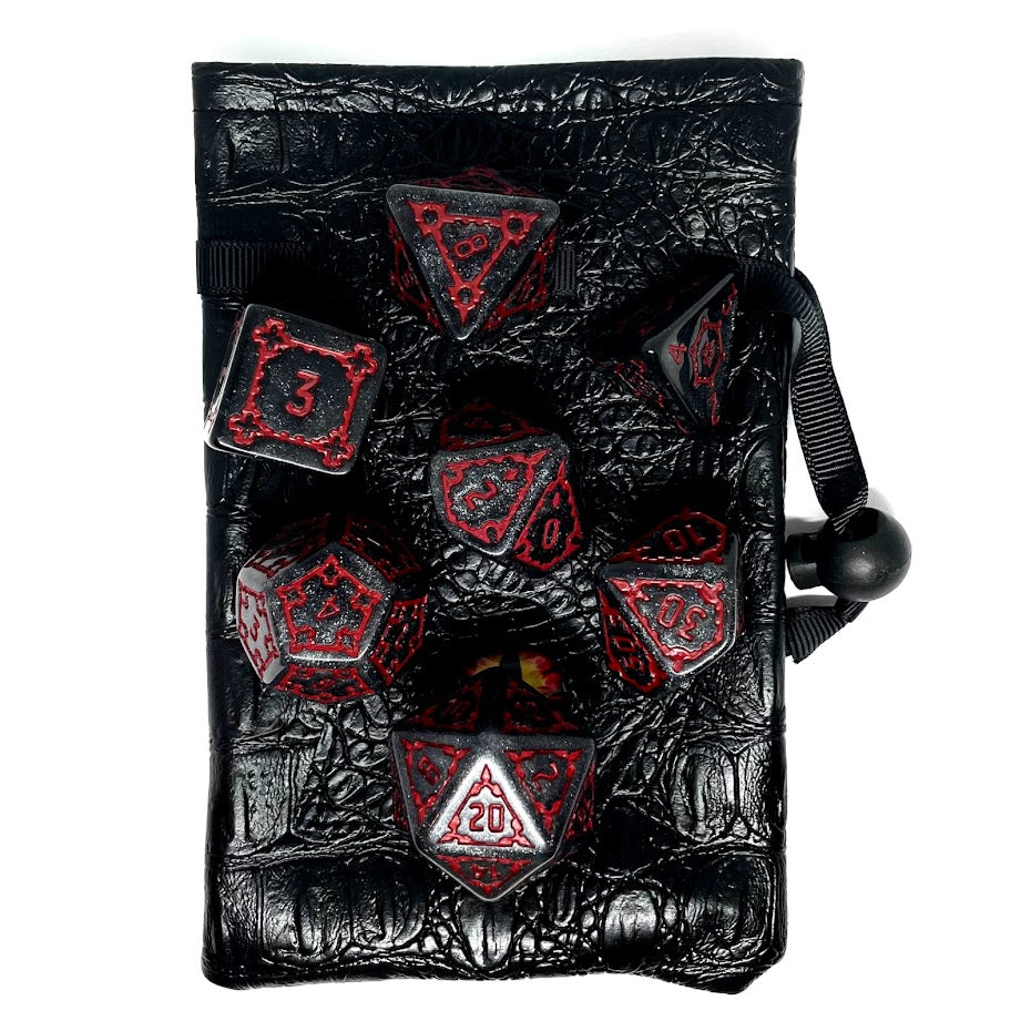 Large Tarrasque plastic dnd dice on top of leather dungeons and dragons dice bag with monster eye